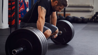 exhaustedlifterrestingonbarbell