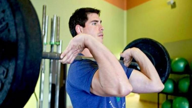 Man holding a loaded barbell in the front rack position