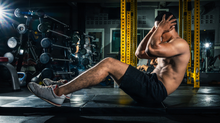 Man in gym performing sit-up