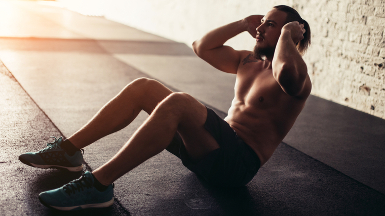 Man on ground performing sit-up