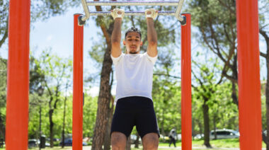 Man performing pull-ups outdoors