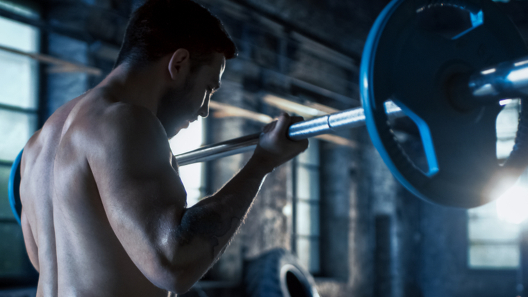 shirtless person curling barbell