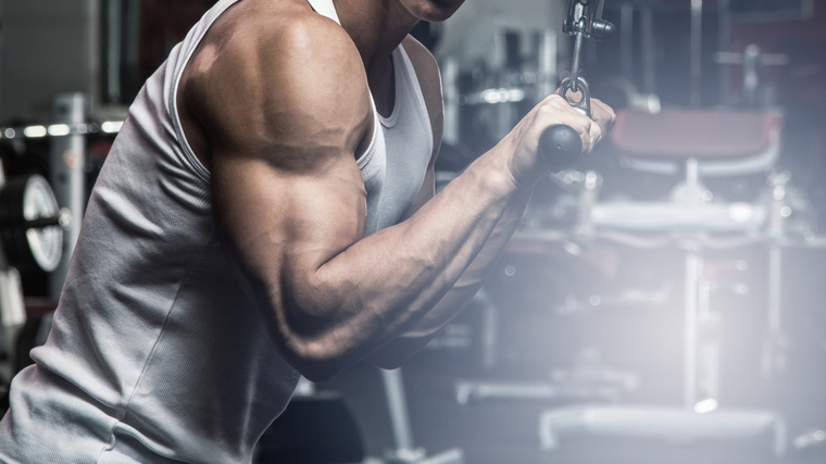 Bodybuilder in gym performing triceps cable exercise