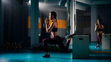 person in gym performing single-leg squat