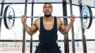 person in gym preparing to barbell squat