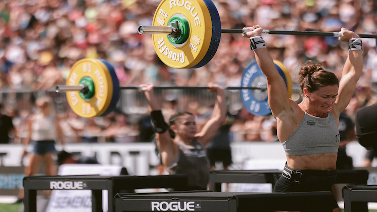 CrossFit Games competitors lifting barbells overhead