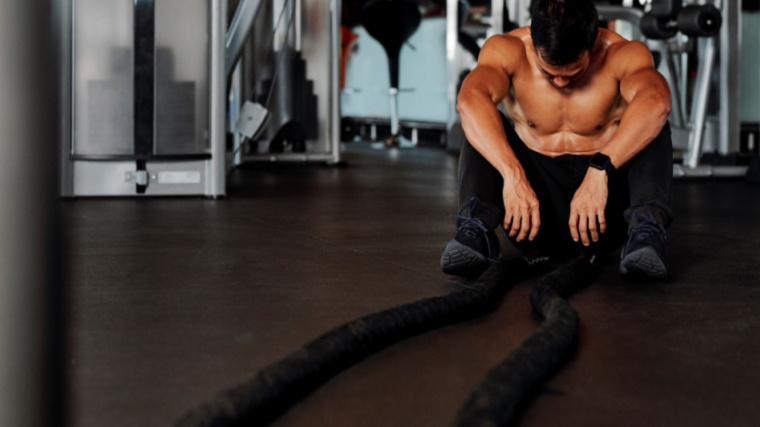 tired person sitting in gym sweating