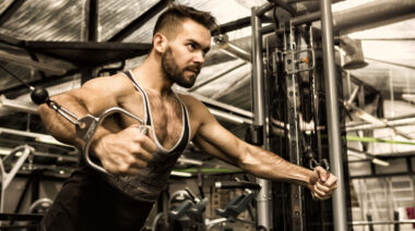 Person in gym performing cable flye exercise