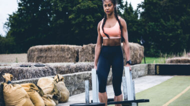 Person outdoors carrying weights in both hands