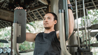 person on chest machine in outdoor gym