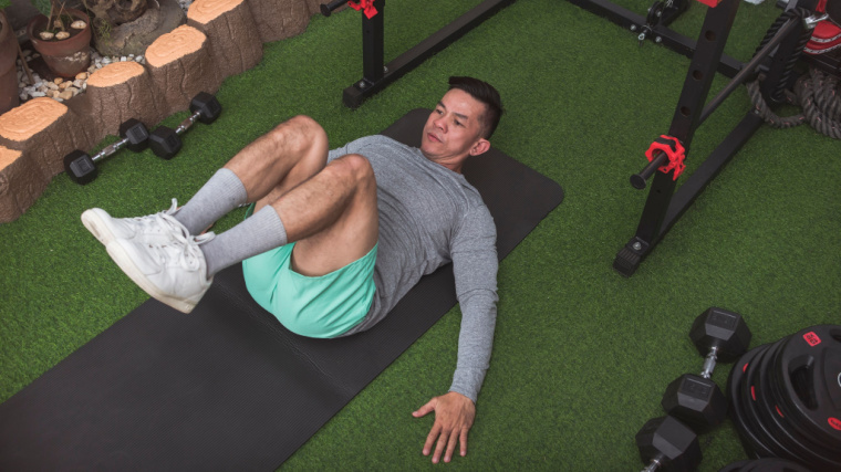 person in gym doing crunch on floor