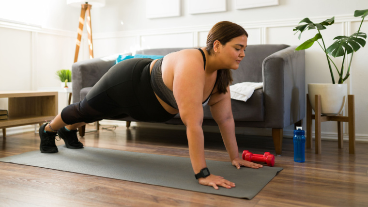 person at home doing push-ups on mat