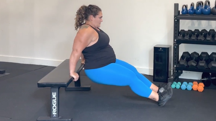 person in gym doing dip on flat bench