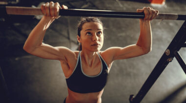 person in gym performing pull-up