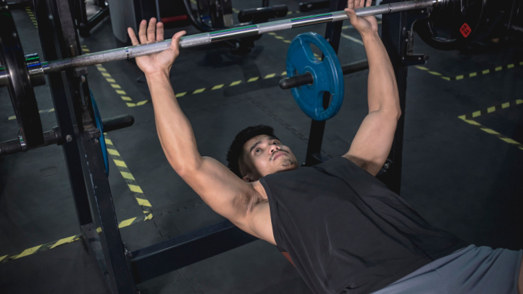 person in gym preparing to bench press