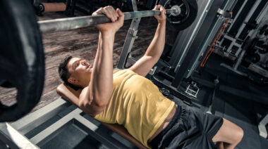 person in gym doing bench press