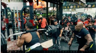 Powerlifter Larry Wheels squatting with a safety bar in front of legendary bodybuilder Ronnie Coleman.