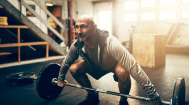 Person in gym preparing to lift barbell