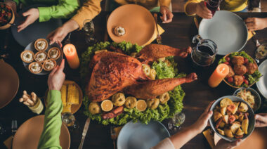 people at dinner table with turkey