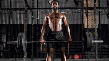 Muscular person doing barbell deadlift