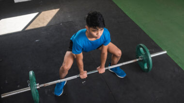 overhead view of person in gym doing sumo deadlift