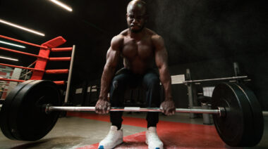 Muscular person doing barbell deadlift