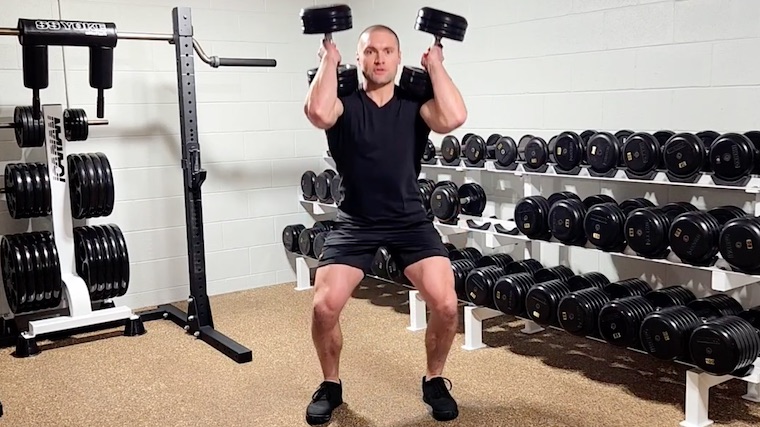 Dr. Merrick Lincoln in gym performing dumbbell squat.