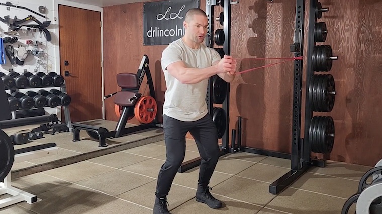 Dr. Merrick Lincoln in gym doing resistance band ab exercise