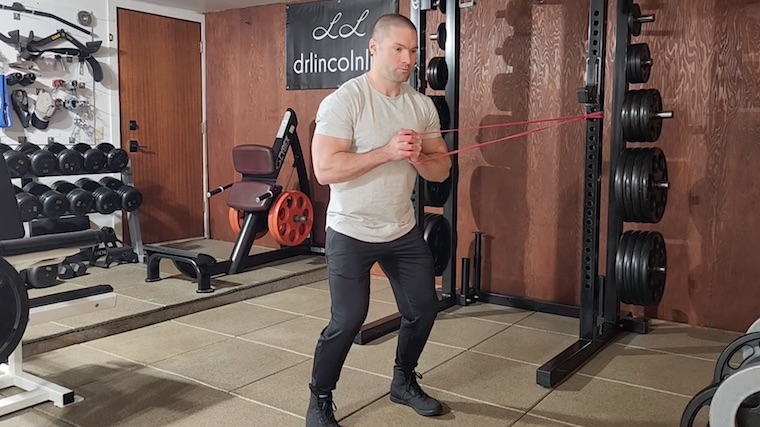 Dr. Merrick Lincoln in gym doing resistance band ab exercise