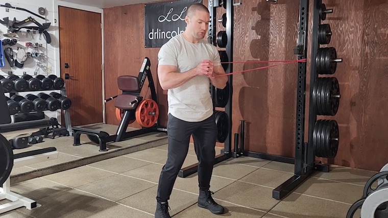 Dr. Merrick Lincoln in gym performing resistance band ab exercise