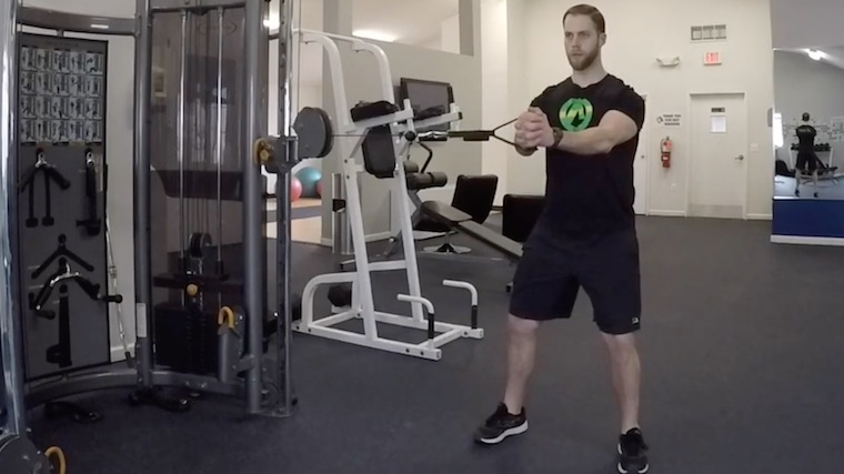 person in gym doing cable ab exercise