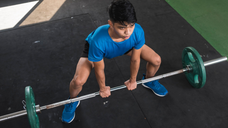 Person in gym doing sumo deadlift