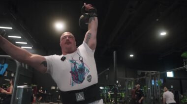 Strongman Mitchell Hooper holding kettlebell overhead