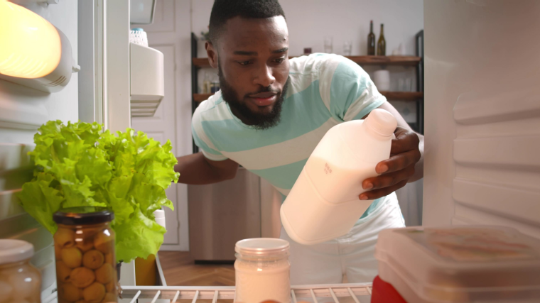 Person taking milk out of refrigerator