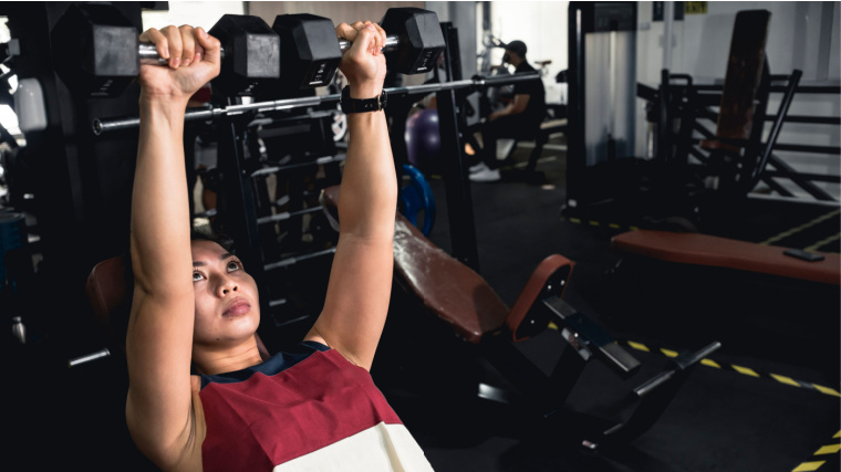 person in gym doing incline dumbbell press