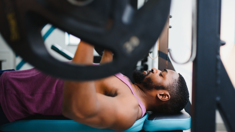 Person in gym doing bench press