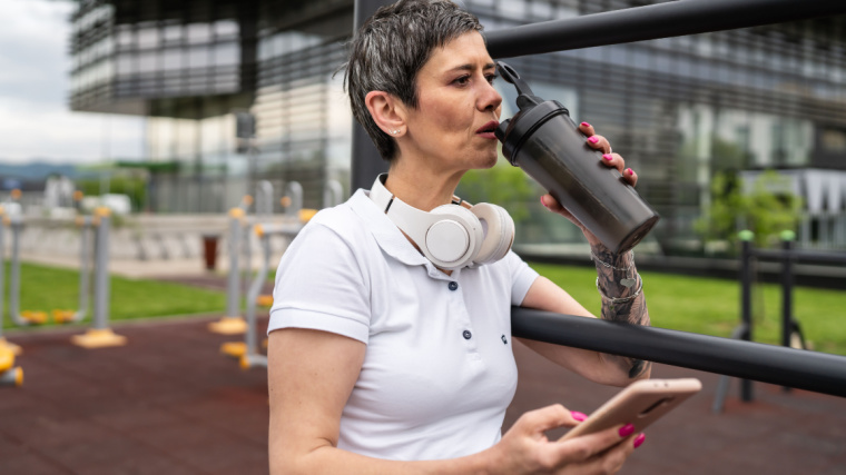 Person drinking protein shake outdoors