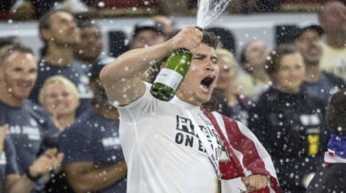 Justin Medeiros spraying champagne bottle 2022 CrossFit Games