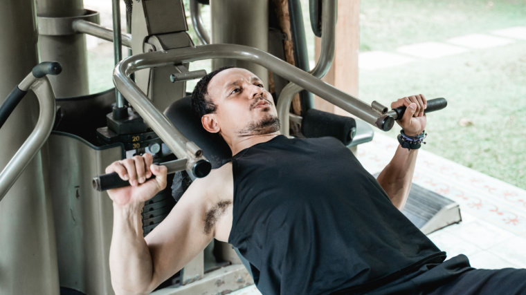 Person in outdoor gym using chest press machine