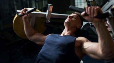 Person in gym performing chest press on machine