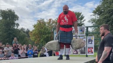 Strongman Laurence Shahlaei performing Dinnie stone carry outdoors