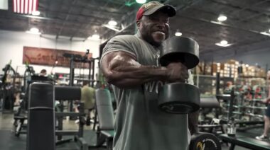 Bodybuilder Shaun Clarida in gym performing dumbbell curl