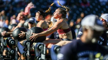 Female competitors performing medicine ball sit-ups at the 2022 Rogue Invitational.